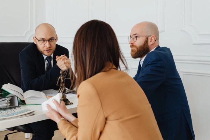 Three professionals in a legal consultation meeting at a modern office.