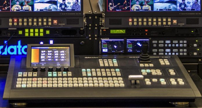 Video production control room with switcher and live feed monitors