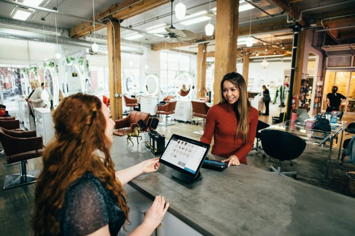 Salon employee helping customer using digital AI system