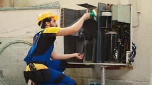 Technician cleaning an outdoor AC unit with a brush.