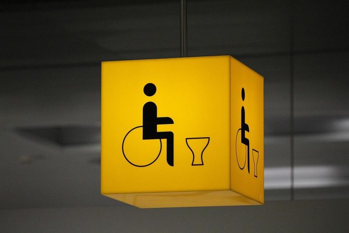 ADA compliant restroom sign in commercial building ceiling.